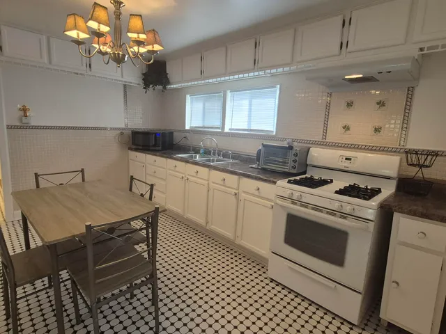 a kitchen with a stove cabinets and wooden floor