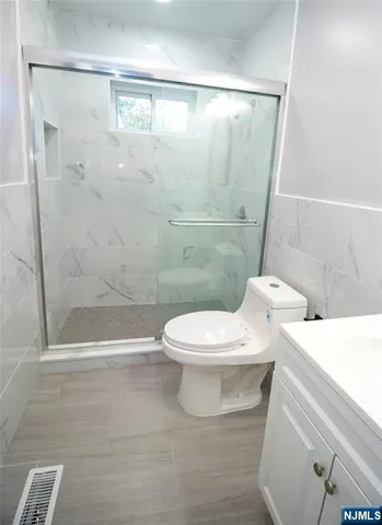 a white toilet sitting next to a bath tub and a shower
