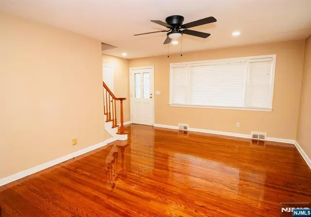 a view of a room with wooden floor and a ceiling fan