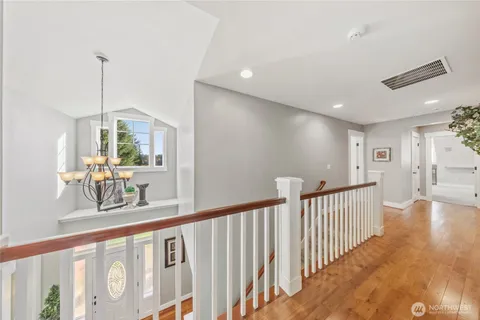 a view of a hallway with wooden floor and windows