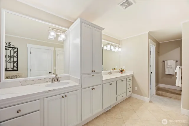 a spacious bathroom with double sink and a mirror
