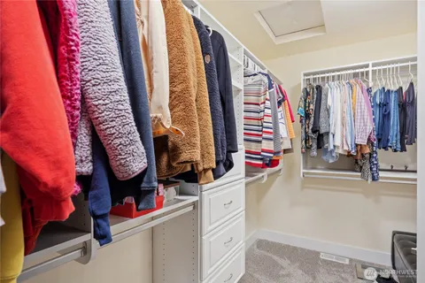 a view of walk in closet with clothes and shoes