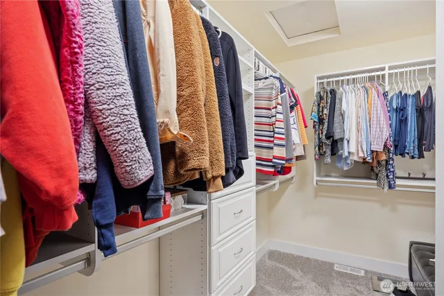 a view of walk in closet with clothes and shoes