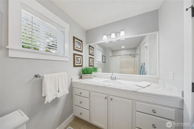 a bathroom with a sink vanity granite toilet and a mirror