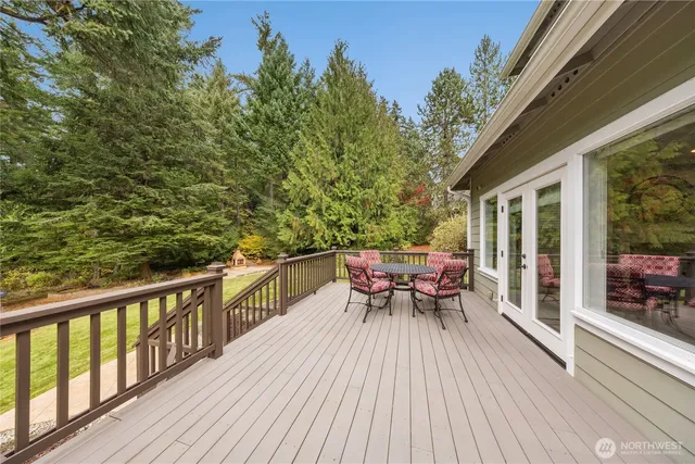a view of a deck with furniture and trees in the front