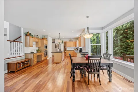 a dining room with furniture window wooden floor and a chandelier