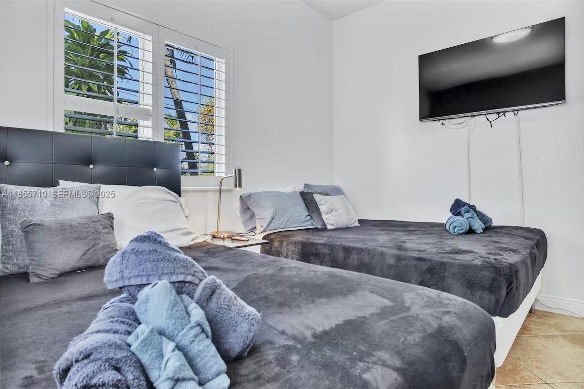 205 North 31st Avenue, Unit 1 Hollywood, FL 33021 - Photo 13 of 42 a bedroom with bed and a flat screen tv