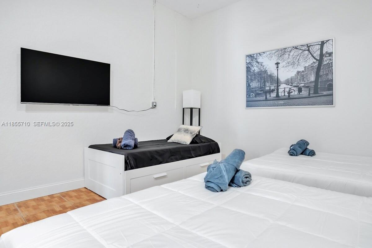 205 North 31st Avenue, Unit 1 Hollywood, FL 33021 - Photo 19 of 42 a bedroom with a bed and a flat screen tv