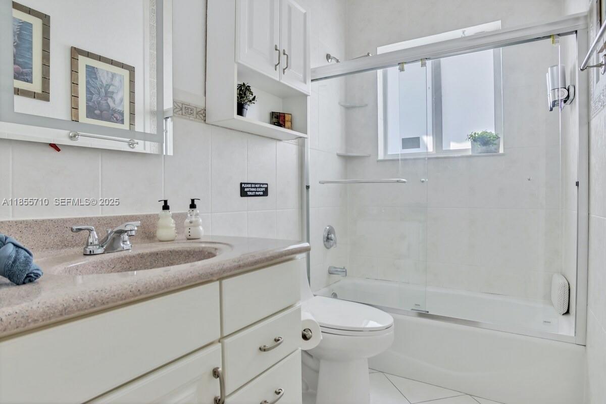 205 North 31st Avenue, Unit 1 Hollywood, FL 33021 - Photo 20 of 42 a bathroom with a granite countertop sink a toilet and shower