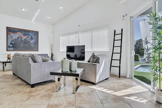 a kitchen with kitchen island granite countertop a sink and white cabinets