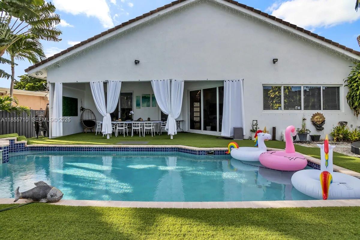 205 North 31st Avenue, Unit 1 Hollywood, FL 33021 - Photo 3 of 42 a view of swimming pool with a table and chairs