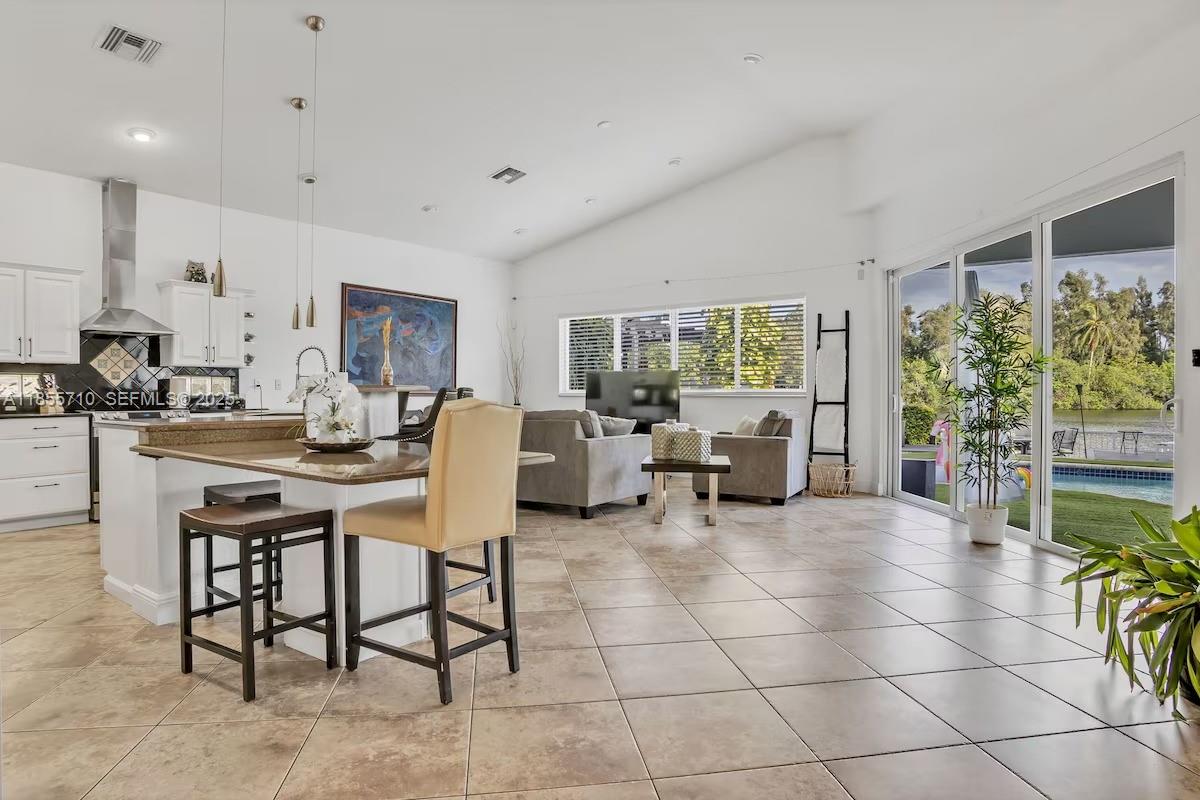 205 North 31st Avenue, Unit 1 Hollywood, FL 33021 - Photo 33 of 42 a living room with couches a coffee table and a dining table with garden view
