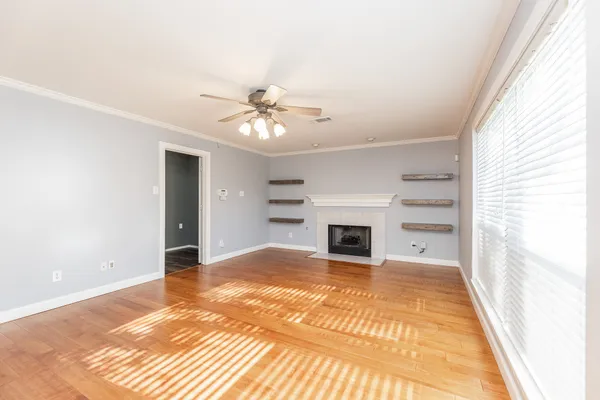 a view of an empty room with a fireplace and a window