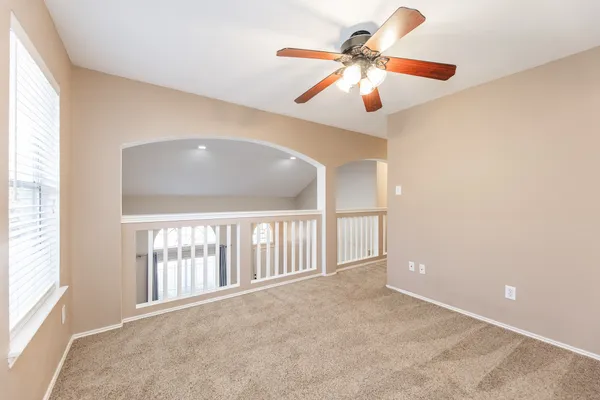 a view of a room with a ceiling fan and a window