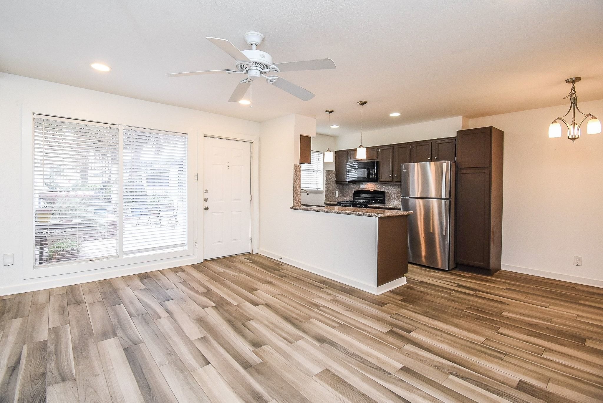 1404 Welch Street, Unit 2 Houston, TX 77006 - Photo 2 of 20 Spacious open living area with wood-look flooring, recessed lighting, and seamless connection to the kitchen and dining spaces.