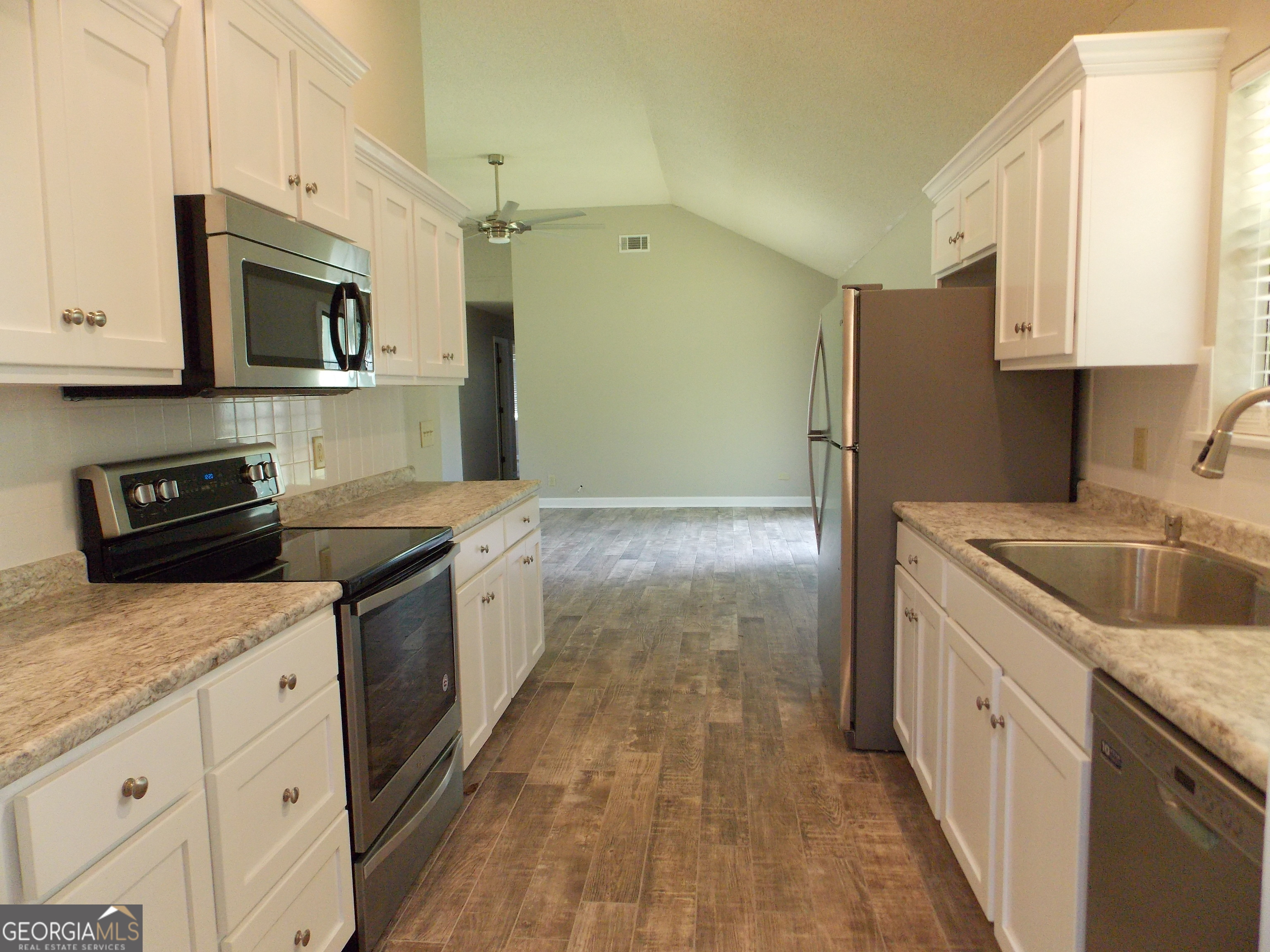 224 Pretoria Rushing Road Statesboro, GA 30461 - Photo 4 of 11 a kitchen with granite countertop a sink a stove top oven a refrigerator and cabinets