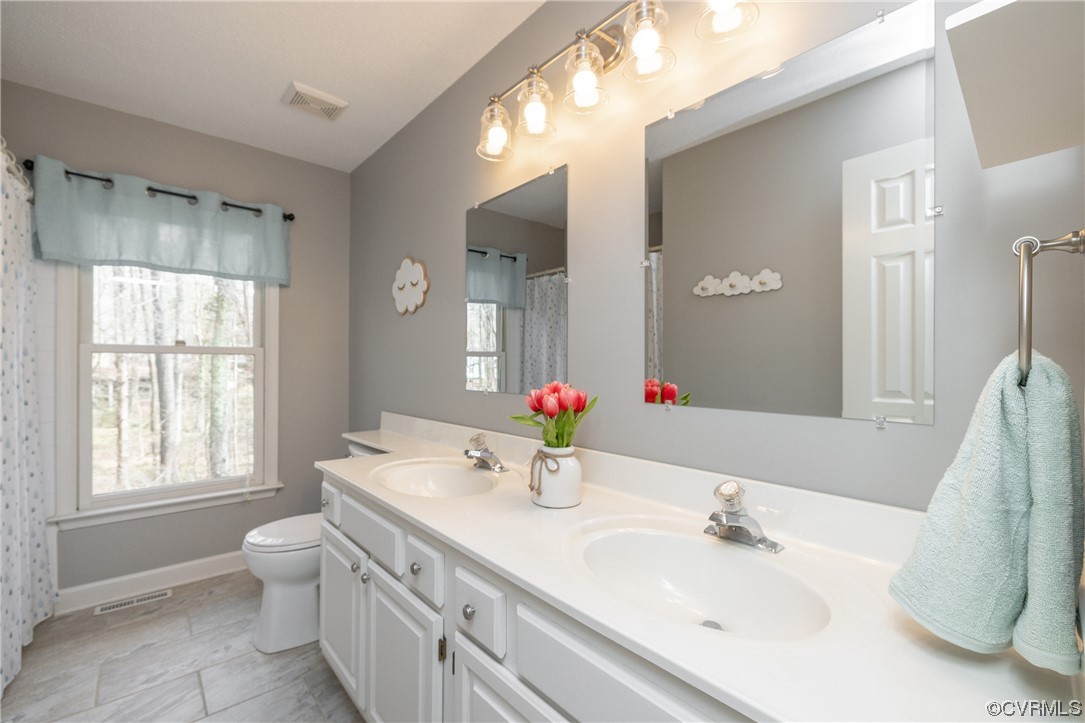 2905 Cove Ridge Road Midlothian, VA 23112 - Photo 41 of 48 a bathroom with a double vanity sink window and a mirror