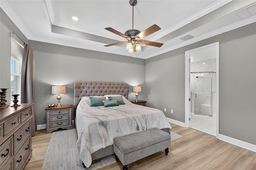 5961 Blakeney Loop Apollo Beach, FL 33572 - Photo 12 of 42 a bedroom with a large bed and a chandelier