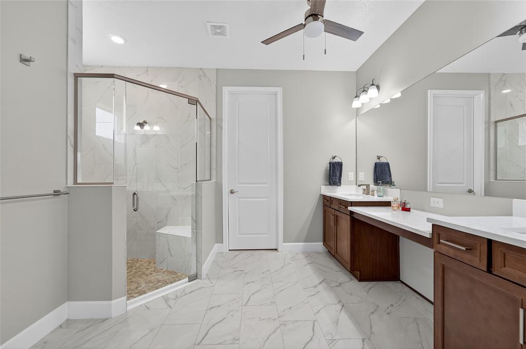 5961 Blakeney Loop Apollo Beach, FL 33572 - Photo 13 of 42 a spacious bathroom with a shower sink mirror and toilet