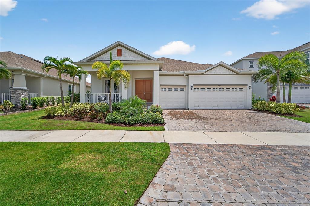 5961 Blakeney Loop Apollo Beach, FL 33572 - Photo 2 of 42 a front view of a house with a yard and garage
