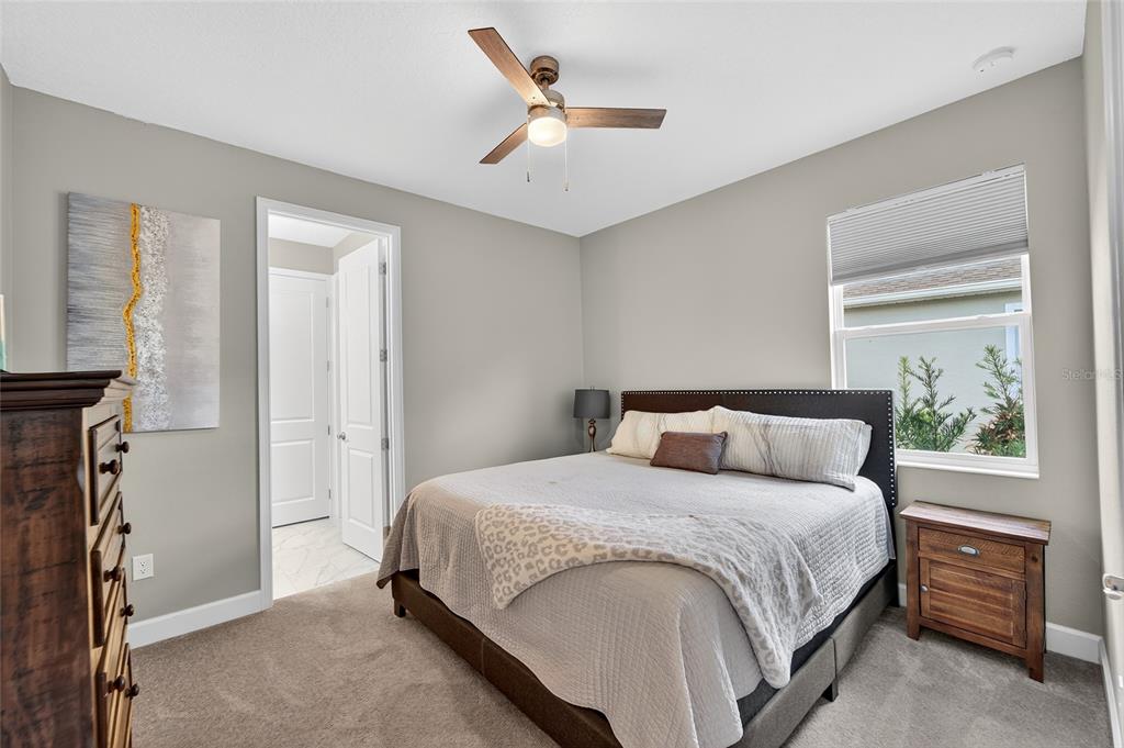 5961 Blakeney Loop Apollo Beach, FL 33572 - Photo 25 of 42 a bedroom with a large bed and a chandelier