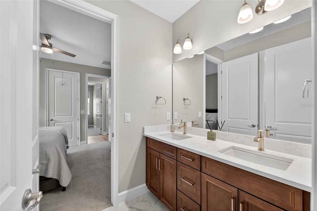5961 Blakeney Loop Apollo Beach, FL 33572 - Photo 26 of 42 a bathroom with a double vanity sink a mirror and a shower