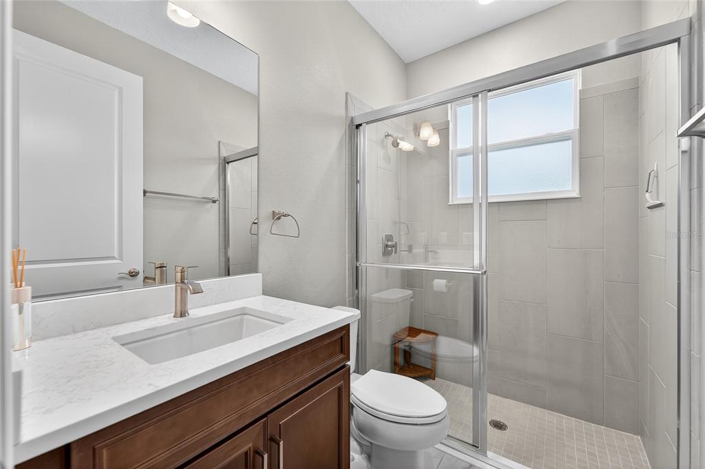 5961 Blakeney Loop Apollo Beach, FL 33572 - Photo 28 of 42 a bathroom with a sink toilet a mirror and shower