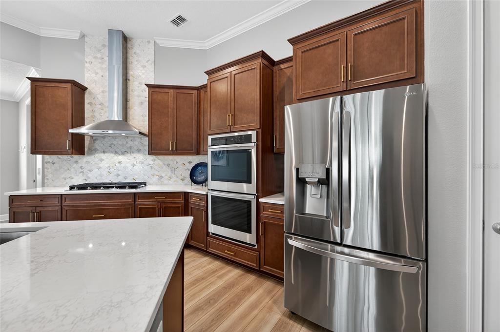 5961 Blakeney Loop Apollo Beach, FL 33572 - Photo 5 of 42 a kitchen with stainless steel appliances granite countertop a refrigerator and a stove top oven