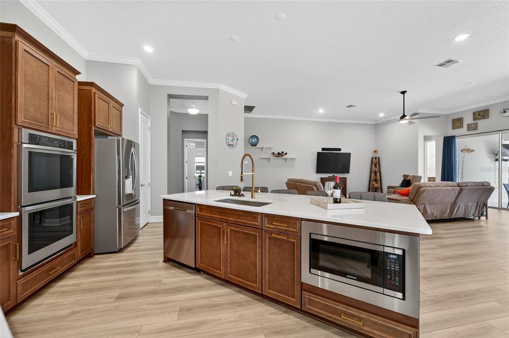 5961 Blakeney Loop Apollo Beach, FL 33572 - Photo 7 of 42 a kitchen with stainless steel appliances a stove a sink and a refrigerator