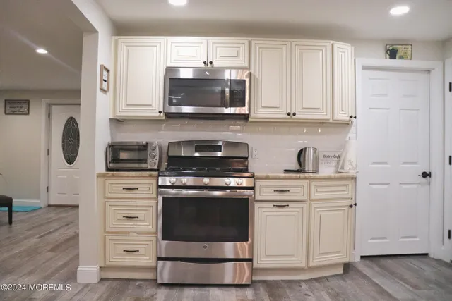 a kitchen with stainless steel appliances granite countertop a stove a microwave and cabinets