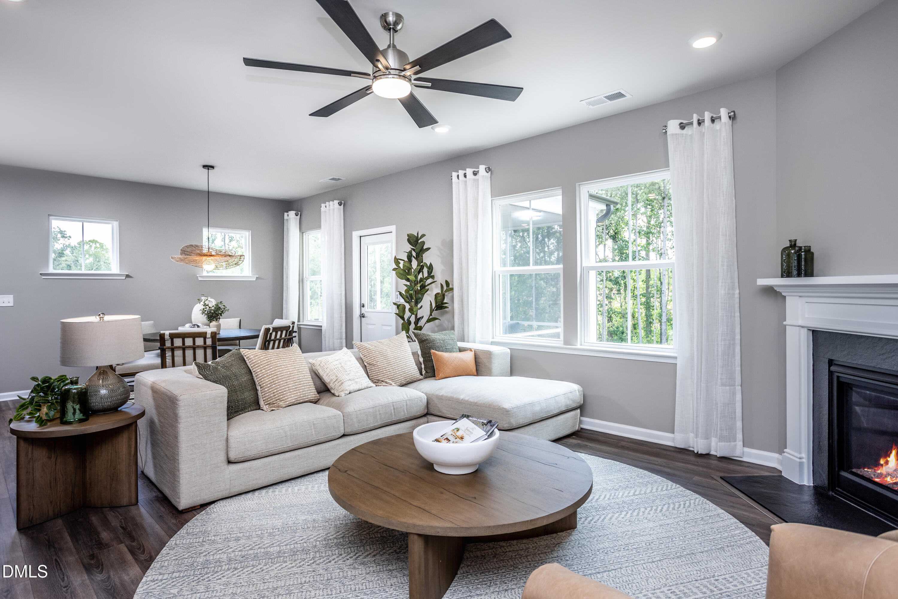 657 Ben Ledi Court Raleigh, NC 27603 - Photo 8 of 32 a living room with furniture a fireplace and a chandelier