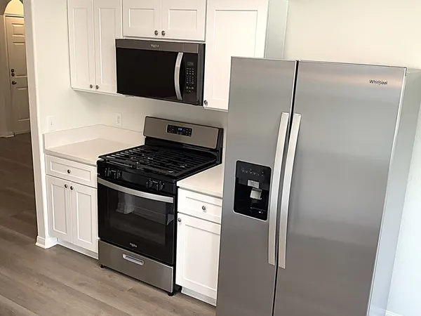 a kitchen with stainless steel appliances a refrigerator stove and microwave