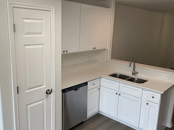 a kitchen with white cabinets and sink