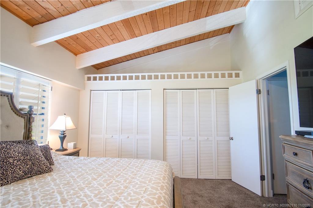 2355 Northeast Ocean Boulevard, Unit 120B Stuart, FL 34996 - Photo 11 of 26 a bedroom with a large bed and a chandelier