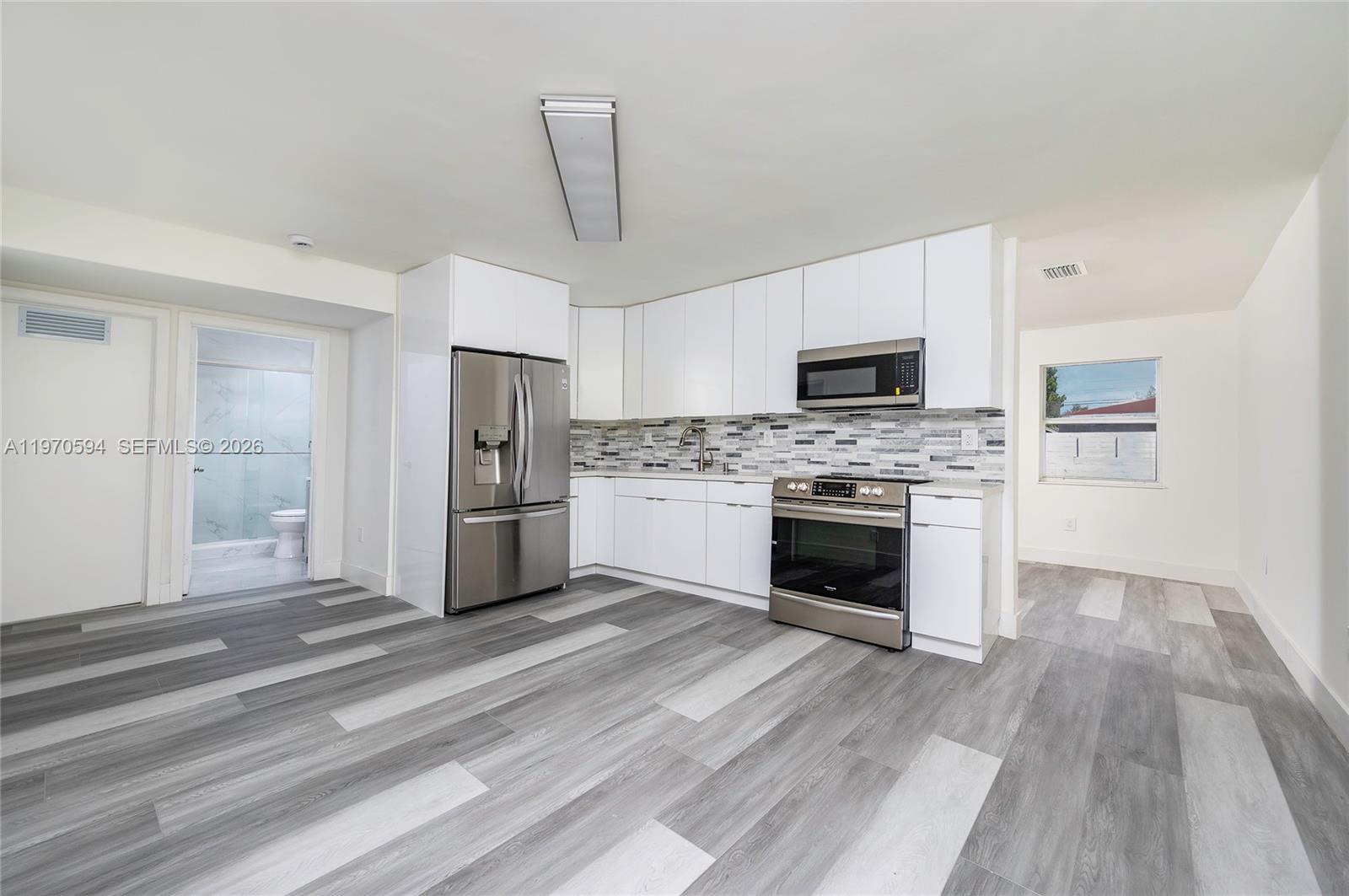 2433 Northwest 97th Street Miami, FL 33147 - Photo 12 of 41 a kitchen with granite countertop a refrigerator oven and a stove top oven