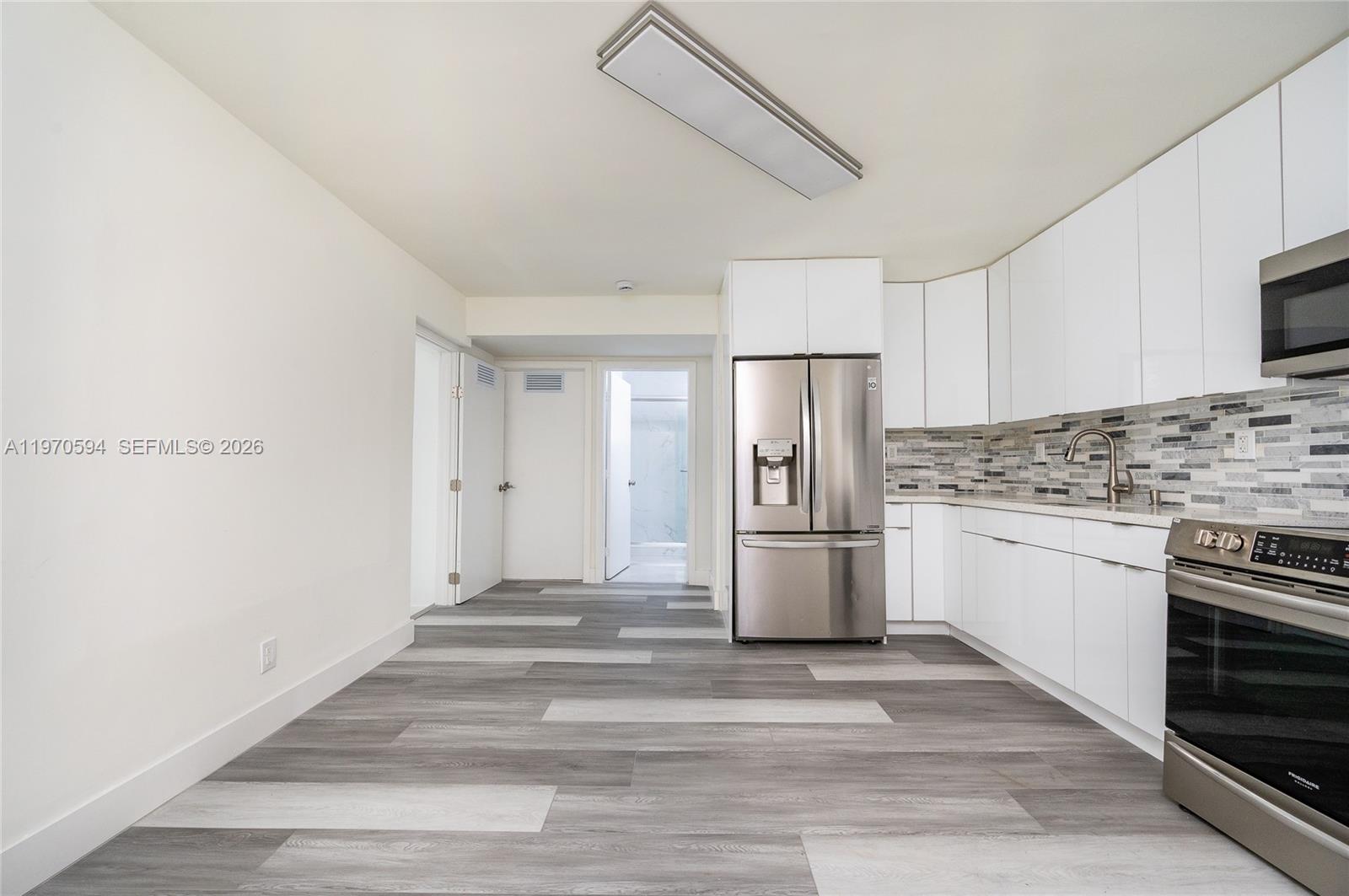 2433 Northwest 97th Street Miami, FL 33147 - Photo 13 of 41 a kitchen with a stove cabinets and refrigerator