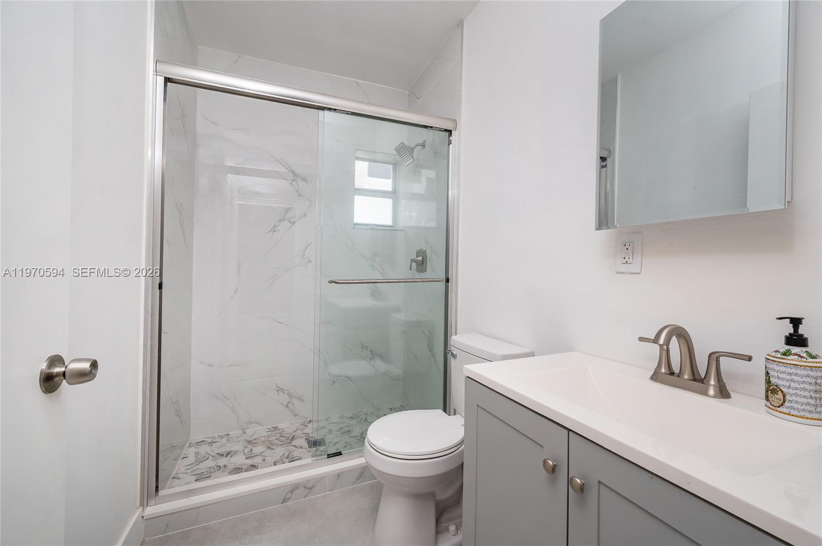 2433 Northwest 97th Street Miami, FL 33147 - Photo 16 of 41 a bathroom with a sink a toilet and shower