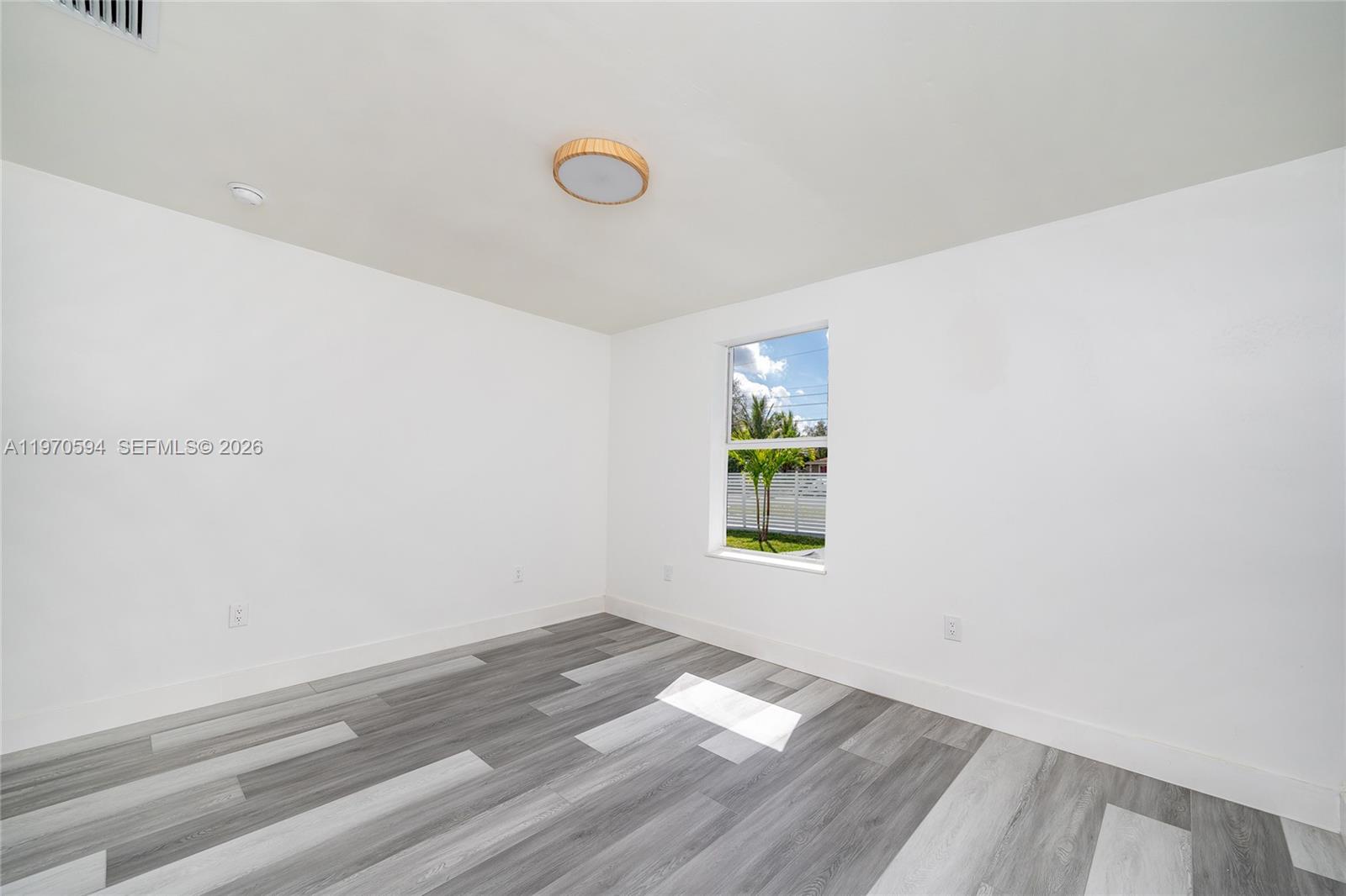 2433 Northwest 97th Street Miami, FL 33147 - Photo 17 of 41 a view of empty room with window and wooden floor
