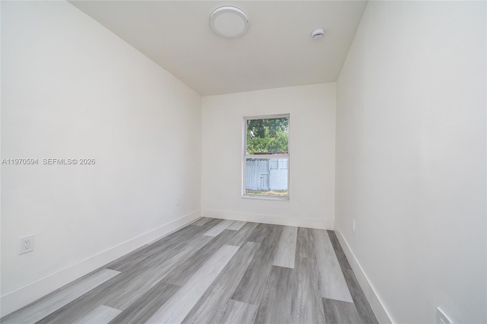 2433 Northwest 97th Street Miami, FL 33147 - Photo 22 of 41 a view of room with window and hardwood floor