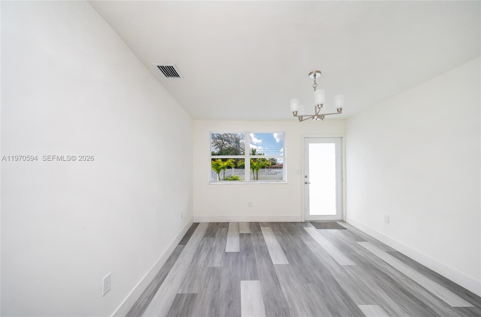 2433 Northwest 97th Street Miami, FL 33147 - Photo 27 of 41 a view of room with window and hardwood floor