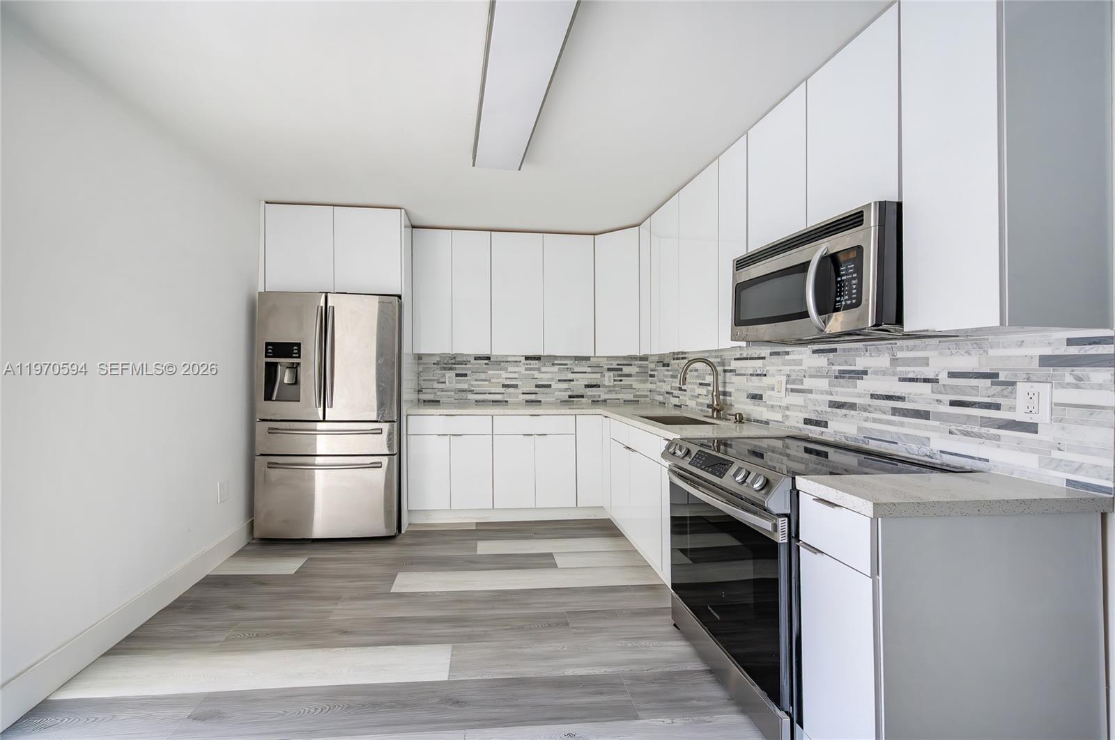 2433 Northwest 97th Street Miami, FL 33147 - Photo 29 of 41 a kitchen with refrigerator stove and microwave