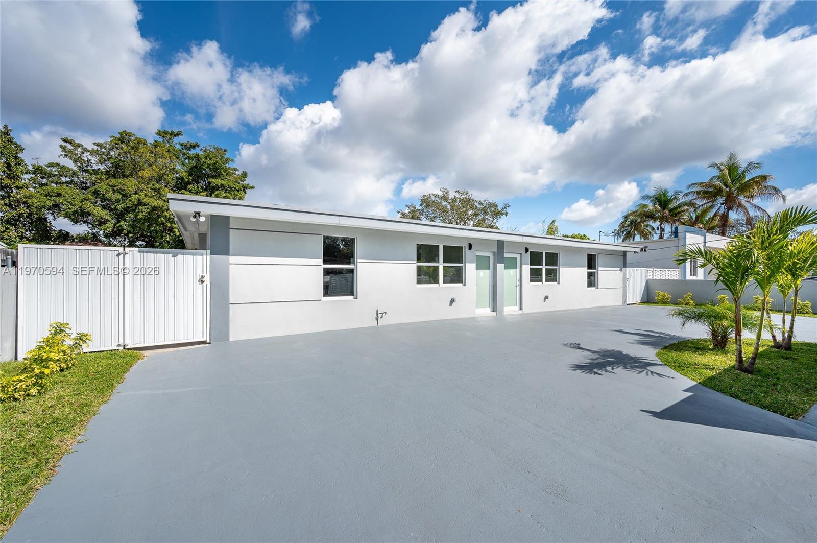 2433 Northwest 97th Street Miami, FL 33147 - Photo 3 of 41 a view of a white house with a yard and plants