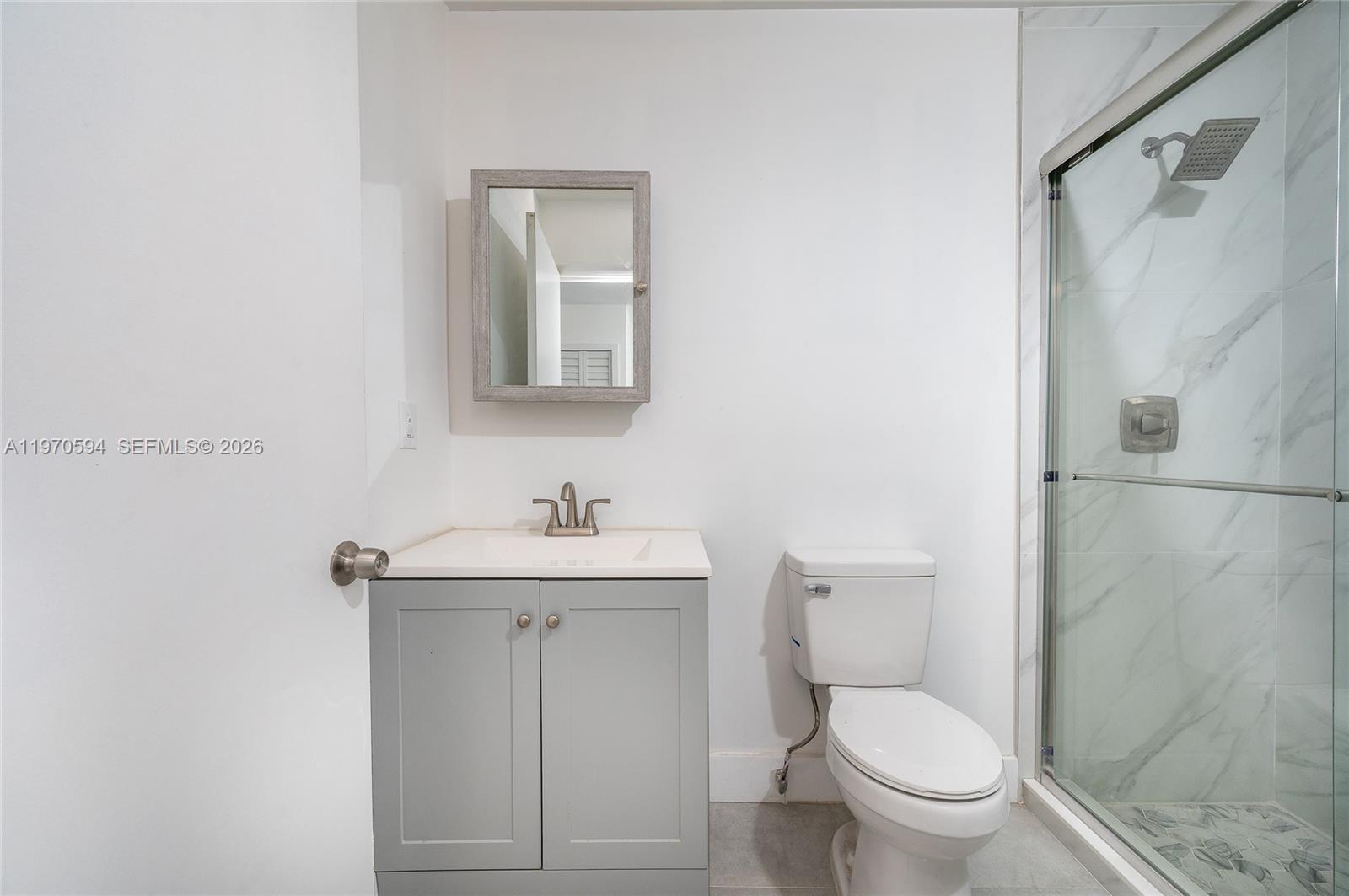 2433 Northwest 97th Street Miami, FL 33147 - Photo 33 of 41 a bathroom with a toilet a sink a shower and mirror