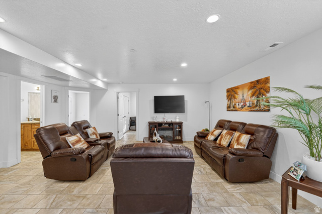 141 Wolverine Creek Elk Ridge, UT 84651 - Photo 23 of 47 Living room featuring a textured ceiling and recessed lighting