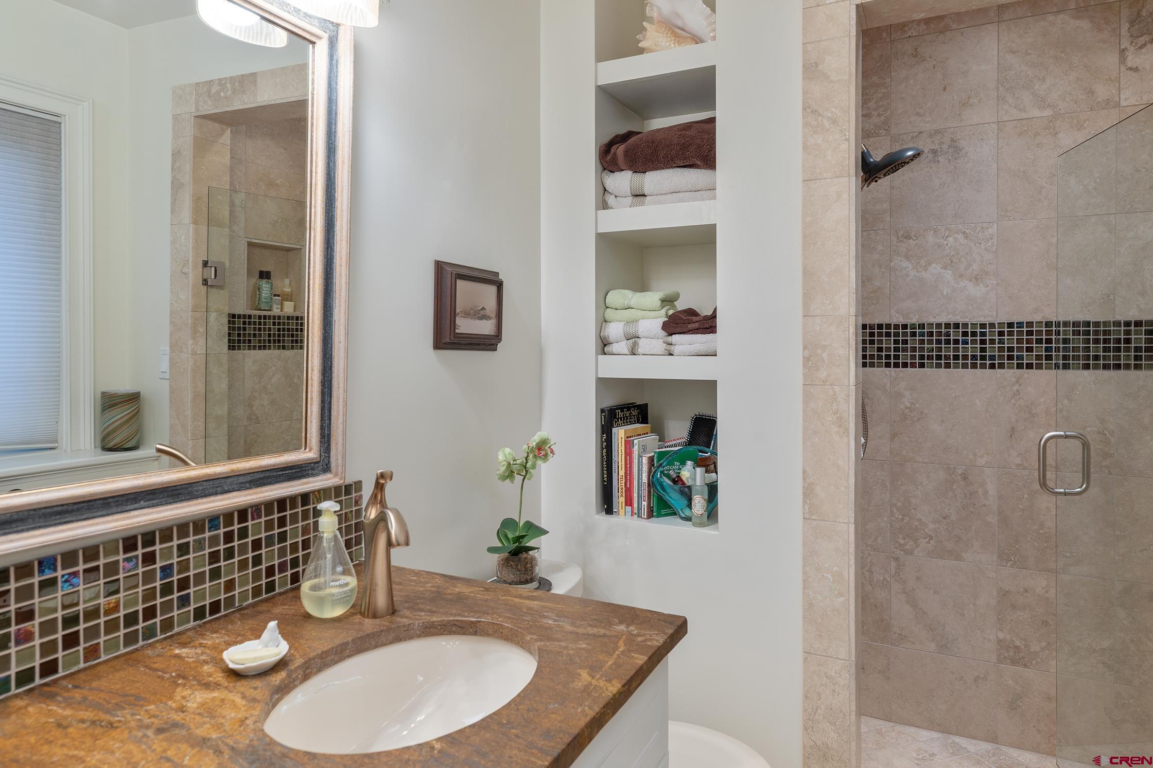 721 East Columbia Avenue Telluride, CO 81435 - Photo 28 of 44 a bathroom with a granite countertop sink a mirror and shower