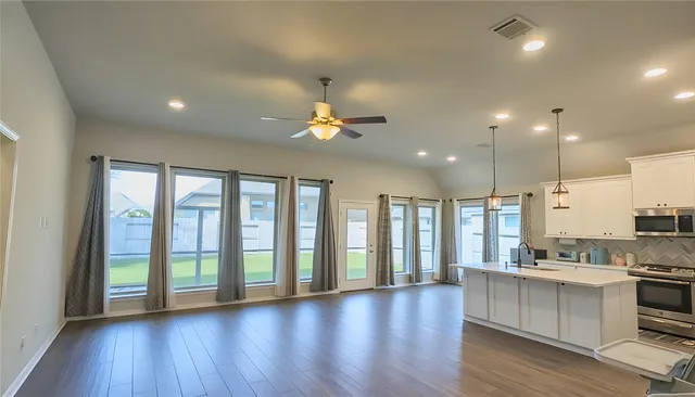 a view of a lake with a yard and large trees