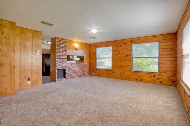 a view of an empty room with a fireplace and a window