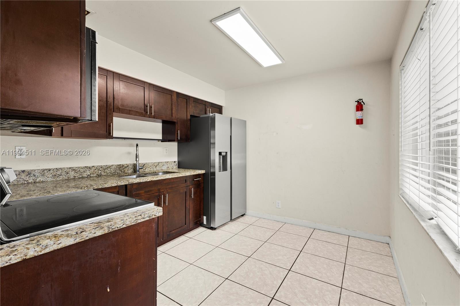 6121 Southwest 40th Court, Unit A Miramar, FL 33023 - Photo 6 of 12 a kitchen with a stove a sink and a refrigerator