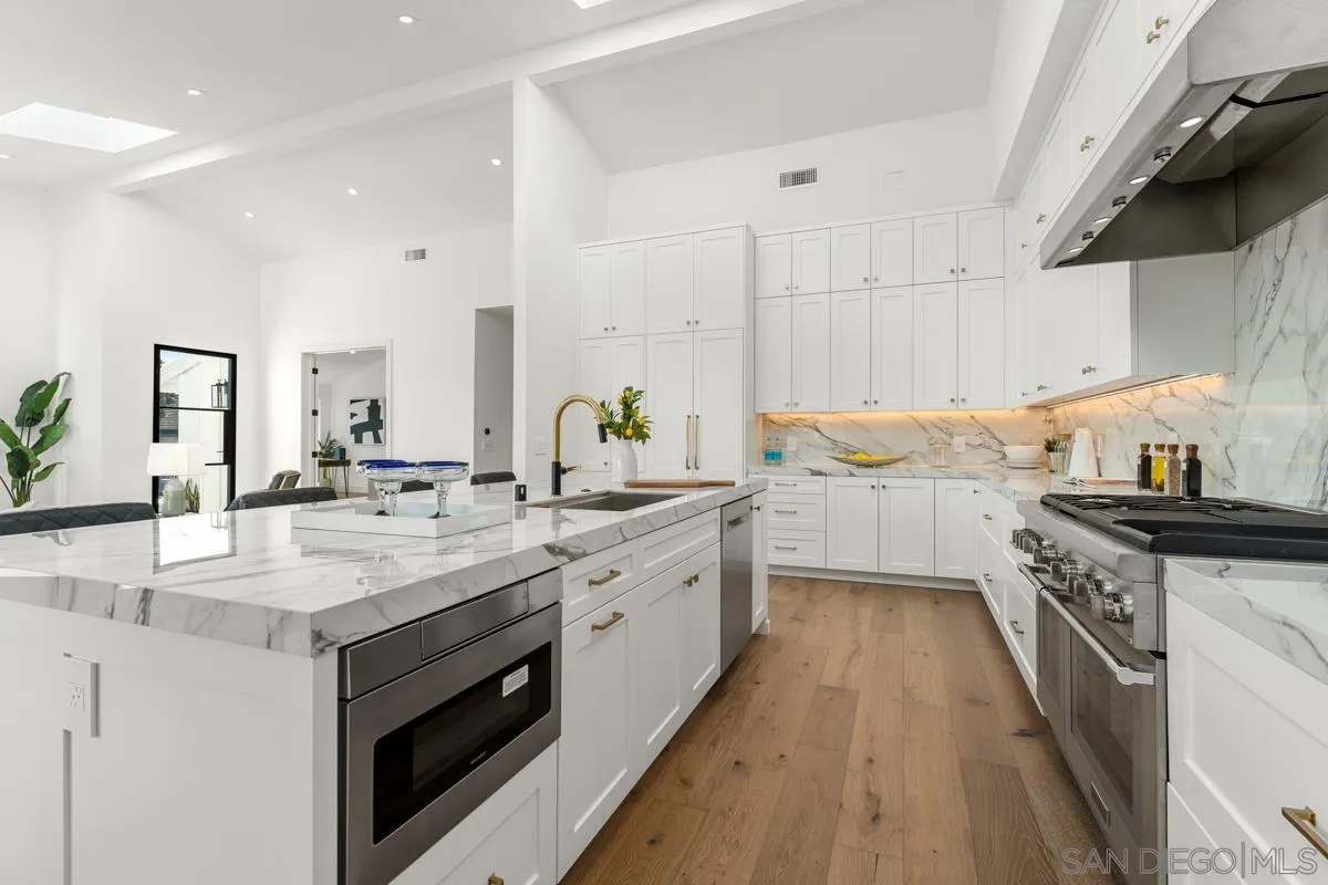 34 Jetty Drive Corona del Mar, CA 92625 - Photo 12 of 33 a kitchen with a sink stove top oven and cabinets