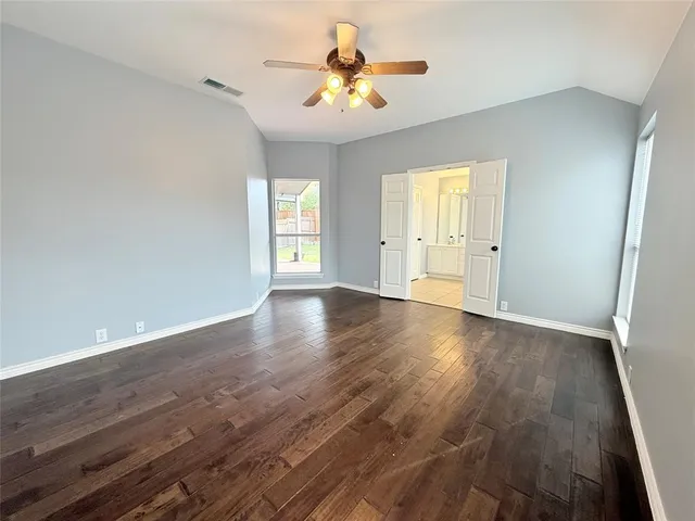 a view of a room with wooden floor and a ceiling fan